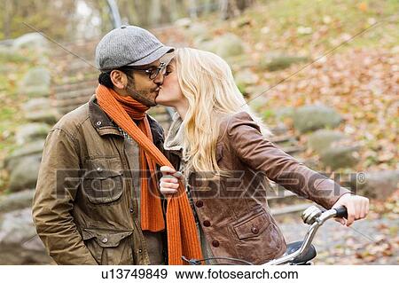 Stock Photo - Couple kissing in park. Fotosearch