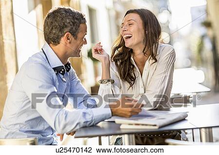 Couple laughing at sidewalk cafe View Large Photo Image Stock Image - Couple laughing at sidewalk cafe. Fotosearch
