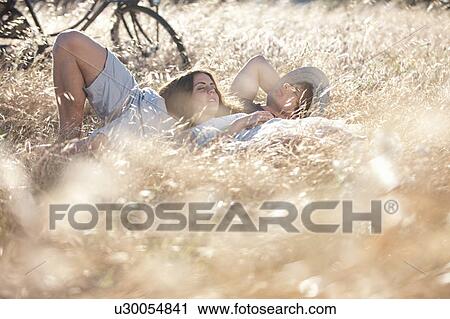 Couple laying in tall grass View Large Photo Image Stock Image - Couple laying in tall grass. Fotosearch