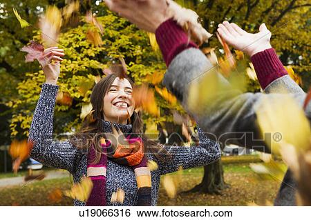 Couple playing in autumn leaves View Large Photo Image Stock Photograph - Couple playing in autumn leaves. Fotosearch