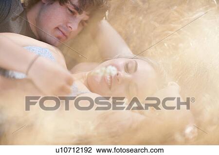 Couple relaxing in tall grass View Large Photo Image Stock Image - Couple relaxing in tall grass. Fotosearch