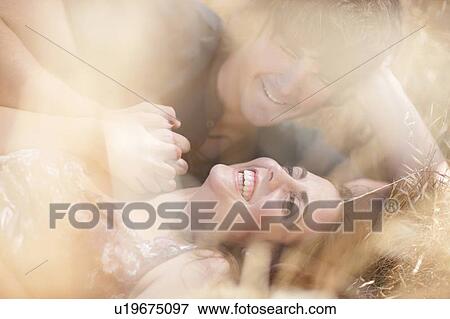 Stock Photo - Couple relaxing in tall grass. Fotosearch