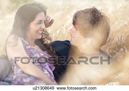 Stock Photo - Couple relaxing in tall grass. Fotosearch