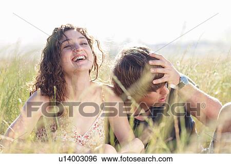 Stock Photograph - Couple relaxing in tall grass. Fotosearch