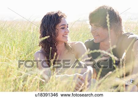 Couple relaxing in tall grass View Large Photo Image Stock Photograph - Couple relaxing in tall grass. Fotosearch