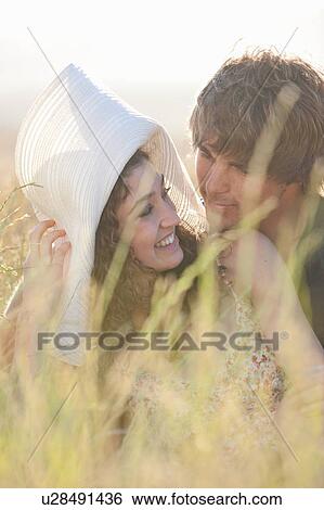 Couple relaxing in tall grass View Large Photo Image Stock Photograph - Couple relaxing in tall grass. Fotosearch