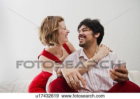 Couple relaxing on sofa together View Large Photo Image Stock Photo - Couple relaxing on sofa together. Fotosearch
