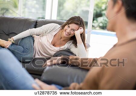 Couple relaxing together in living room View Large Photo Image Stock Photography - Couple relaxing together in living room. Fotosearch