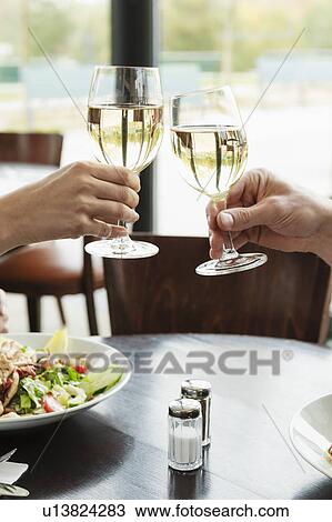 Couple toasting each other at cafe View Large Photo Image Stock Image - Couple toasting each other at cafe. Fotosearch
