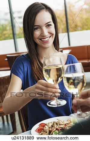 Couple toasting each other at cafe View Large Photo Image Stock Photo - Couple toasting each other at cafe. Fotosearch