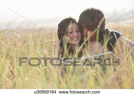 Couple using laptop in tall grass View Large Photo Image Picture - Couple using laptop in tall grass. Fotosearch