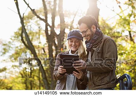 Couple using tablet computer in forest View Large Photo Image Stock Photography - Couple using tablet computer in forest. Fotosearch