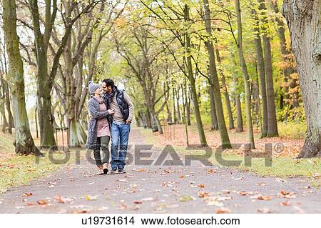 Couple walking together in park View Large Photo Image Picture - Couple walking together in park. Fotosearch