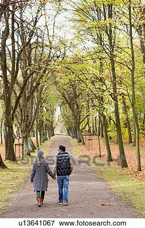 Couple walking together in park View Large Photo Image Stock Photo - Couple walking together in park. Fotosearch