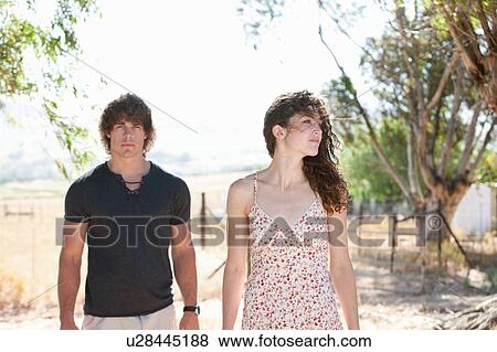 Couple walking together on dirt road View Large Photo Image Stock Photo - Couple walking together on dirt road. Fotosearch