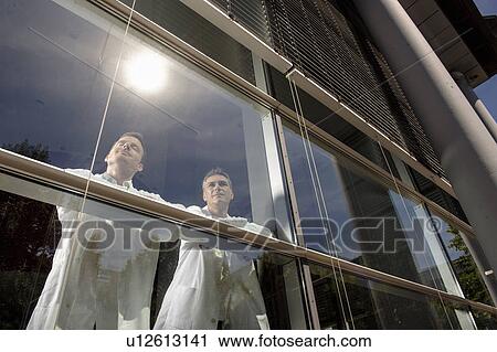 Stock Image - Doctors standing at office window. Fotosearch