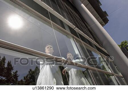 Doctors standing at office window View Large Photo Image Stock Image - Doctors standing at office window. Fotosearch