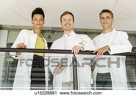Stock Image - Doctors talking on balcony in hospital. Fotosearch