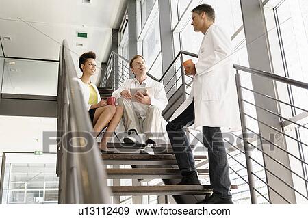 Doctors talking on steps in hospital View Large Photo Image Stock Photo - Doctors talking on steps in hospital. Fotosearch