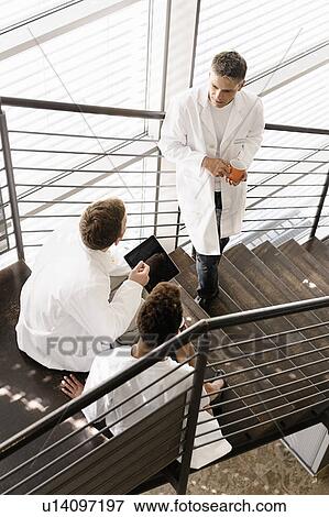 Doctors talking on steps in hospital View Large Photo Image Stock Photo - Doctors talking on steps in hospital. Fotosearch