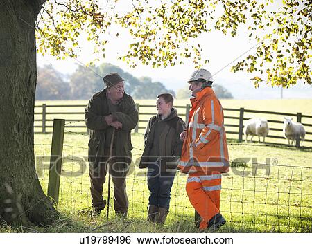 Stock Photograph - Ecologist and farmers talking in field. Fotosearch