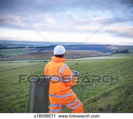 Stock Image - Ecologist examining rural fields. Fotosearch