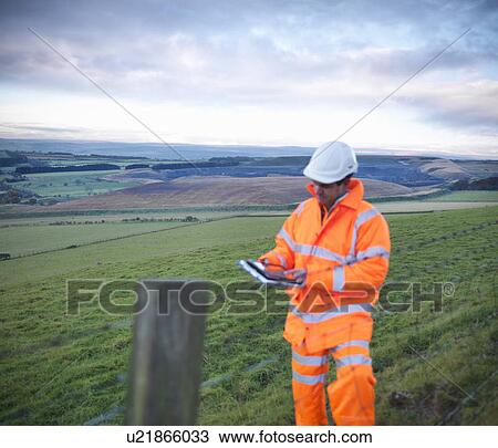 Stock Image - Ecologist examining rural fields. Fotosearch