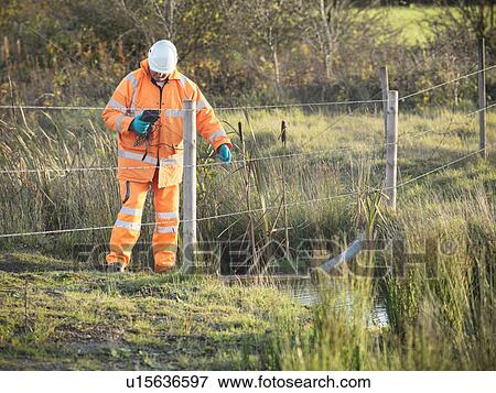Ecologist examining water in creek View Large Photo Image Stock Photo - Ecologist examining water in creek. Fotosearch