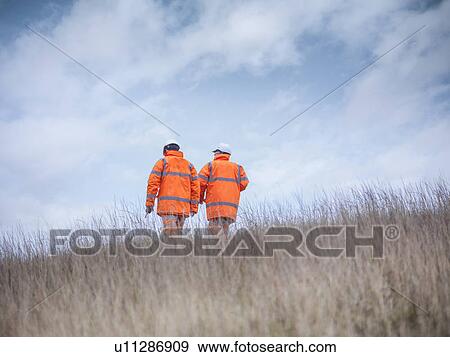 Ecologists walking in tall grass View Large Photo Image Stock Photo - Ecologists walking in tall grass. Fotosearch