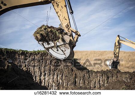 Stock Image - Excavator working at surface coal mine. Fotosearch