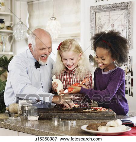 Stock Photo - Family baking Christmas cookies together. Fotosearch