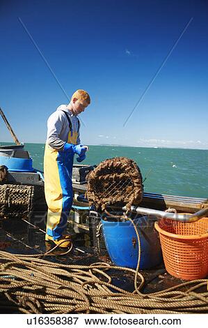 Stock Photo - Fisherman at work on boat. Fotosearch