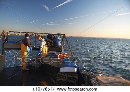 Stock Photo - Fishermen at work on boat. Fotosearch