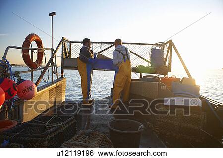 Stock Photograph - Fishermen at work on boat. Fotosearch