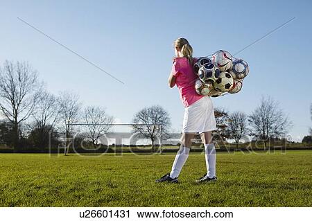 Football player carrying balls in field View Large Photo Image Stock Image - Football player carrying balls in field. Fotosearch