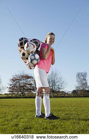 Football player carrying balls in field View Large Photo Image Stock Photo - Football player carrying balls in field. Fotosearch