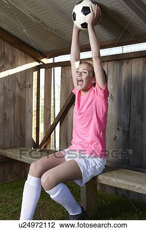 Stock Image - Football player cheering with ball. Fotosearch