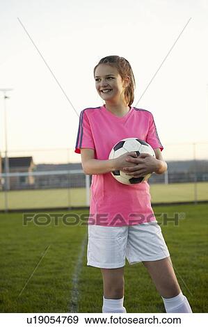 Football player holding ball in field View Large Photo Image Stock Photo - Football player holding ball in field. Fotosearch