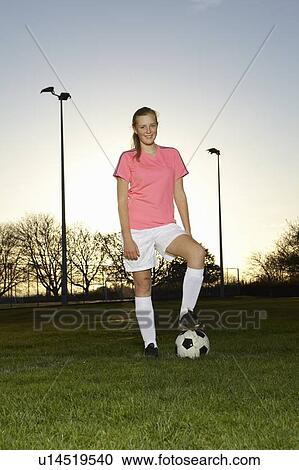 Stock Image - Football player standing with ball. Fotosearch