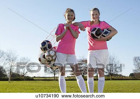Football players carrying balls in field View Large Photo Image Stock Image - Football players carrying balls in field. Fotosearch