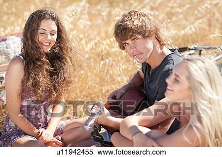 Stock Photography - Friends relaxing in tall grass. Fotosearch