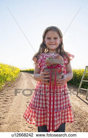 Girl carrying apples on dirt road View Large Photo Image Stock Image - Girl carrying apples on dirt road. Fotosearch