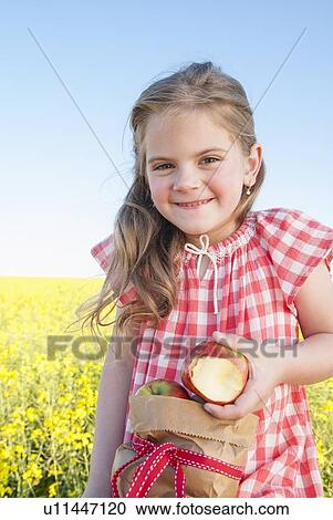 Girl eating sack of apples outdoors View Large Photo Image Stock Image - Girl eating sack of apples outdoors. Fotosearch
