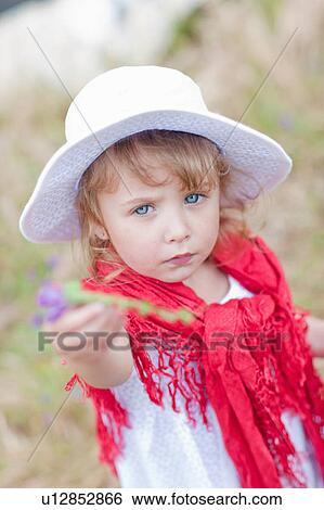 Girl holding flower in field View Large Photo Image Stock Photograph - Girl holding flower in field. Fotosearch