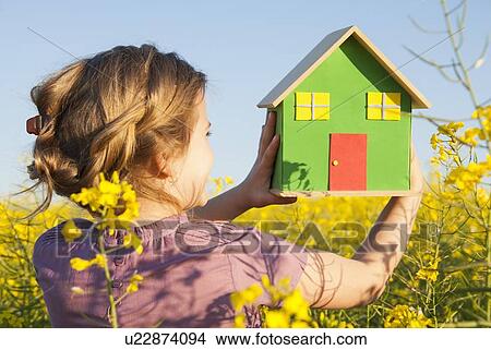 Girl holding model house in field View Large Photo Image Picture - Girl holding model house in field. Fotosearch