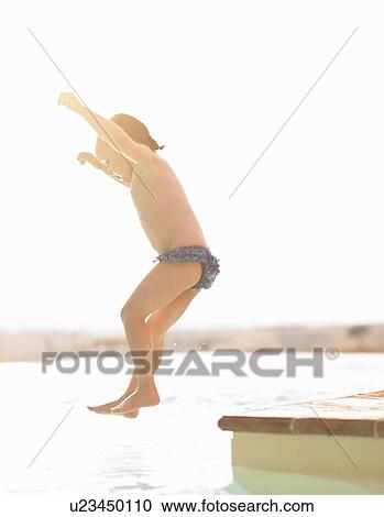 Stock Image - Girl jumping into swimming pool. Fotosearch