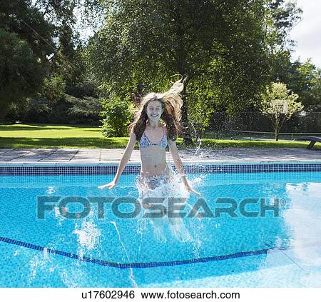 Girl jumping into swimming pool View Large Photo Image Stock Photograph - Girl jumping into swimming pool. Fotosearch