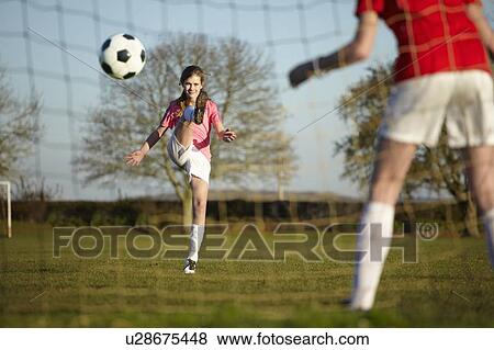 Girl kicking Football ball into goal View Large Photo Image Stock Photo - Girl kicking Football ball into goal. Fotosearch