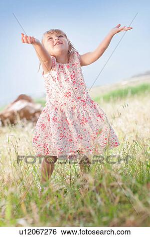 Girl playing in tall grass outdoors View Large Photo Image Stock Photograph - Girl playing in tall grass outdoors. Fotosearch