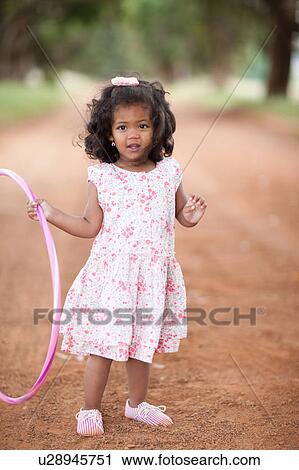 Girl playing with hula hoop on dirt road View Large Photo Image Stock Image - Girl playing with hula hoop on dirt road. Fotosearch